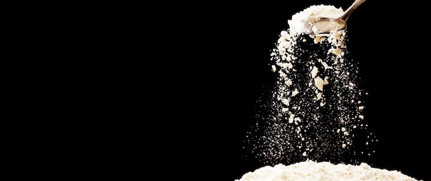 Zdjęcie mąka spada w powietrzu czarne tło izolowane selektywne skupienie