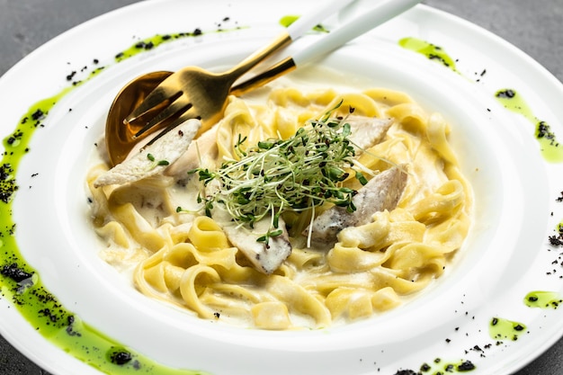 Makaron alfredo z kurczakiem Fettuccine alfredo w kremowym sosie z parmezanem z kurczaka na białym talerzu Kuchnia włoska Menu restauracji dieta książka kucharska przepis widok z góry