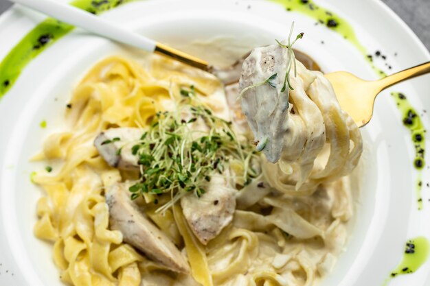 Makaron alfredo z kurczakiem Fettuccine alfredo w kremowym sosie z parmezanem z kurczaka na białym talerzu Kuchnia włoska Menu restauracji dieta książka kucharska przepis widok z góry