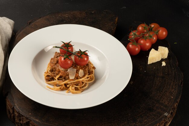 Makaron boloński. Gotowane spaghetti z mięsem mielonym, sosem z pomidorów cherry i parmezanem