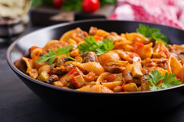 Makaron Conchiglie. Włoskie muszelki makaronu z grzybami, cukinią i sosem pomidorowym.