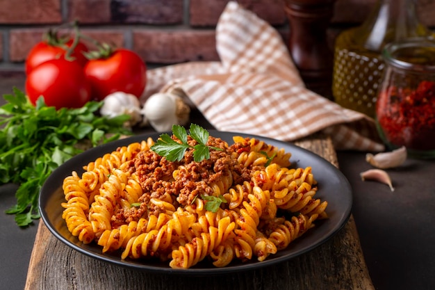 Makaron fusilli, makaron spiralny lub spirali z pomidorami, sosem mielonym - włoski styl jedzenia