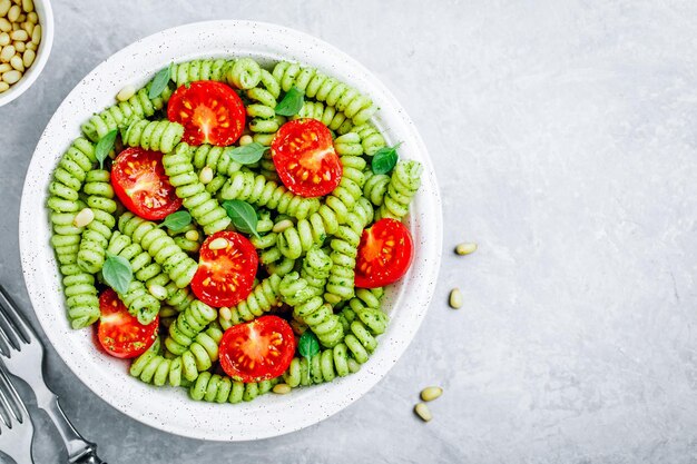 Makaron Fusilli z pomidorami w sosie bazyliowym pesto i orzeszkami pinii Widok z góry Kopia miejsca