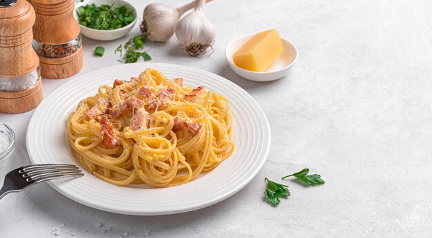 Makaron Linguini z klasycznym sosem carbonara na szarym tle Tradycyjne włoskie jedzenie Widok z boku miejsca do skopiowania