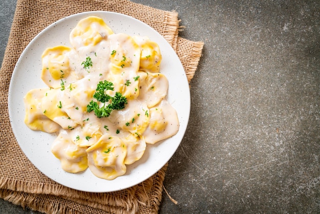 Zdjęcie makaron ravioli z sosem śmietanowo-grzybowym i serem