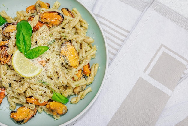 Makaron roślinny z pesto z małży i parmezanem Gotowa do spożycia zdrowa żywność porcja podana na kamiennym stole Twardy, jasny, ciemny cień, płaski widok z góry