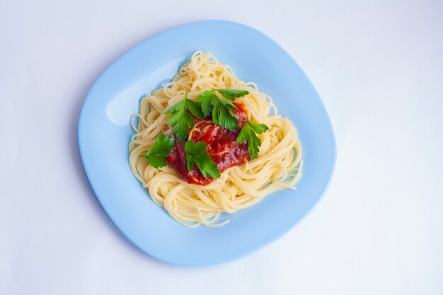 Makaron Spaghetti Z Sosem Pomidorowym I Ziołami W Niebieskim Talerzu Na Białym Tle