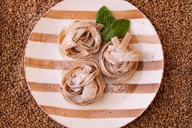 Makaron. Włoskie jedzenie. Surowy produkt cukierniczy kuchni włoskiej z ekologicznej mąki pszennej lub ciasta.