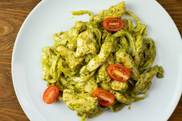 Makaron z kawałkami kurczaka pesto bazyliowym i pomidorami Pyszny obiad