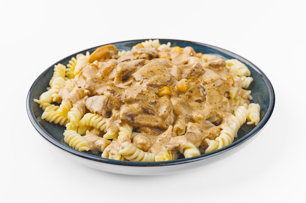 Zdjęcie makaron z mięsem i sosem śmietanym na talerzu na białym tle