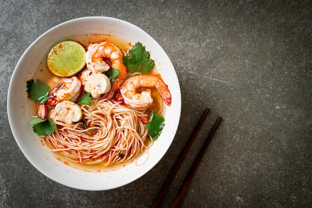 makaron z pikantną zupą i krewetkami w białej misce (Tom Yum Kung) - kuchnia azjatycka