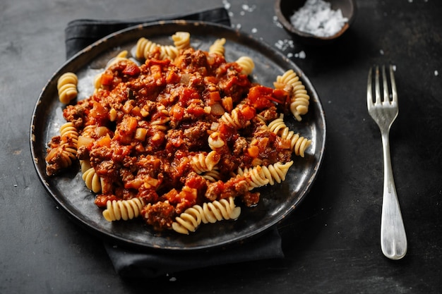 Makaron Z Sosem Bolognese Podawany Na Talerzu Na Ciemnym Tle