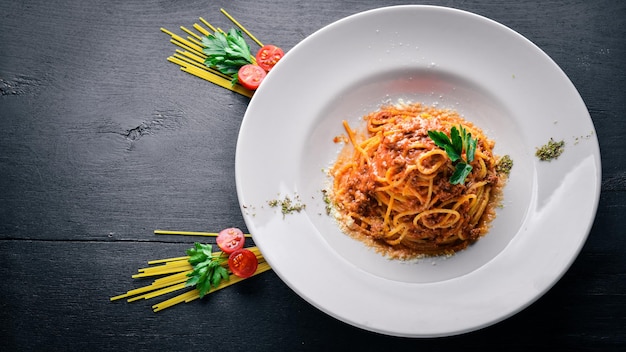 Makaron z sosem pomidorowym i parmezanem Włoskie tradycyjne jedzenie Na drewnianym tle Widok z góry Wolne miejsce na tekst