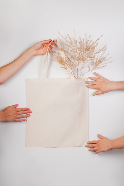 Makieta bawełniana ręcznie robiona eko torba na zakupy w ręku biała torebka wykonana na białym tle z...