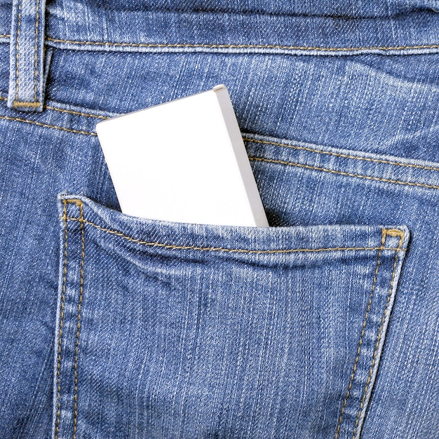 Zdjęcie makieta białego pudełka w tylnej kieszeni niebieskich dżinsów