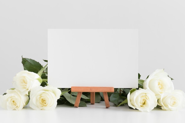 Zdjęcie makieta białej karty z różami na białym stole