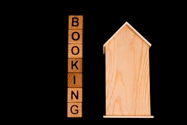 Makieta drewnianego domu z kluczami do domu drewniane kostki ze słowami wynajem sprzedaż kupno i pożyczka na czarnym tle