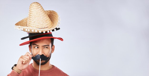 Zdjęcie makieta foto budki kapelusz i twarz mężczyzny w studio z wąsami dla komicznego humoru i zabawnego żartu szczęśliwy meksykański dodatek do imprezy i podekscytowany mężczyzna na szarym tle z sombrero do komedii