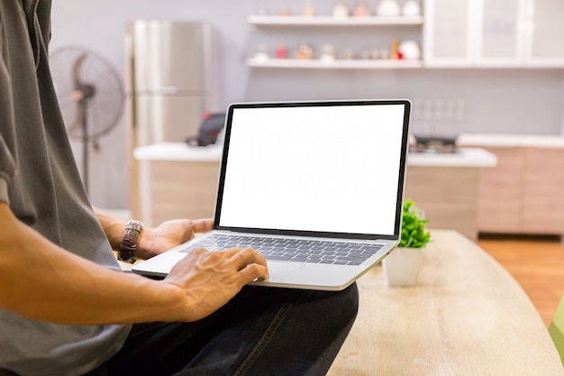 Makieta obraz biznesmena za pomocą laptopa z pustym białym ekranie pulpitu pracy w domu