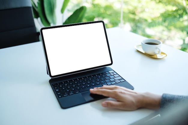 Makieta obrazu kobiety dotykającej touchpada tabletu z pustym białym ekranem pulpitu jako komputer PC w biurze
