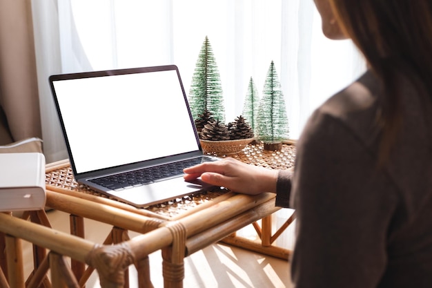 Makieta obrazu kobiety pracującej i dotykającej touchpada laptopa z pustym ekranem w domu