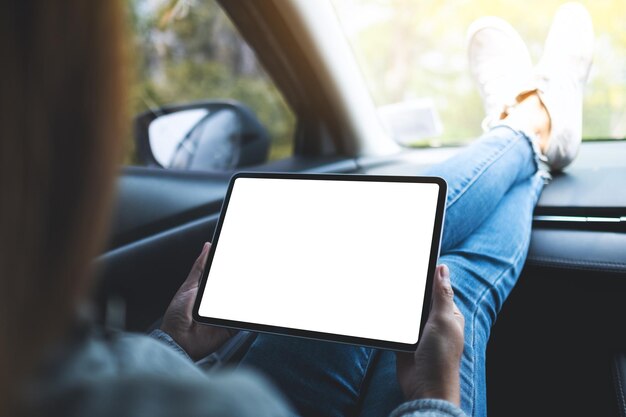 Makieta obrazu kobiety trzymającej i używającej cyfrowego tabletu z pustym ekranem w samochodzie