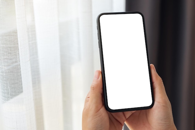 Makieta obrazu kobiety trzymającej telefon komórkowy z pustym białym ekranem pulpitu