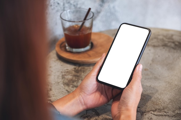 Makieta obrazu kobiety trzymającej telefon komórkowy z pustym białym ekranem pulpitu