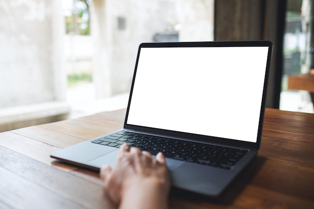 Makieta obrazu kobiety używającej i dotykającej touchpada laptopa z pustym białym ekranem pulpitu