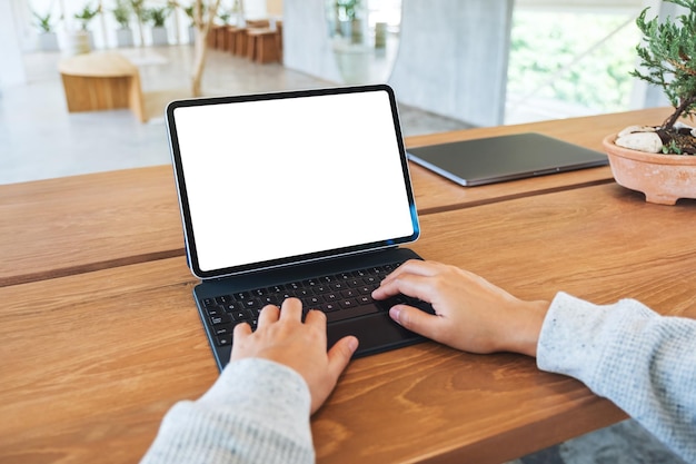Makieta obrazu kobiety używającej i piszącej na klawiaturze tabletu z pustym białym ekranem pulpitu jako komputer PC na stole