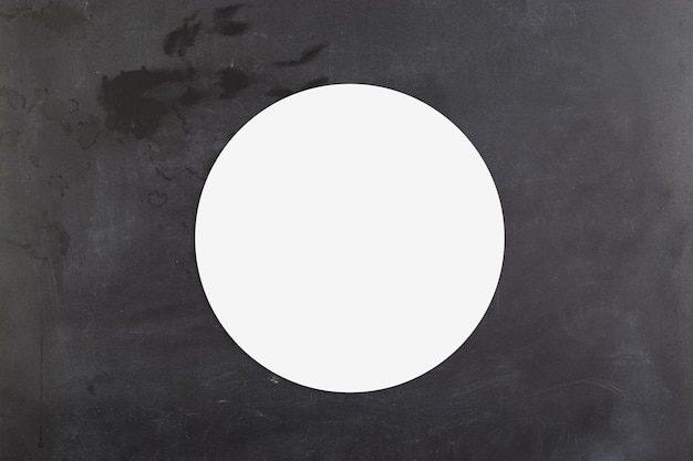 Makieta okrągłej naklejki na powierzchni czarnej tablicy