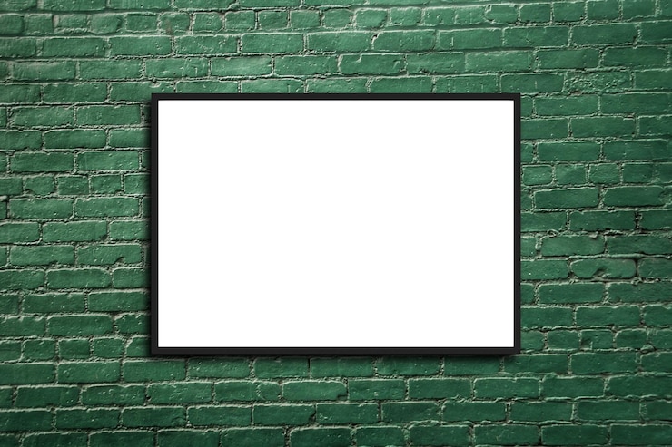 Zdjęcie makieta pusta ramka na plakat wisząca na zielonym tle ściany z cegły w pokoju