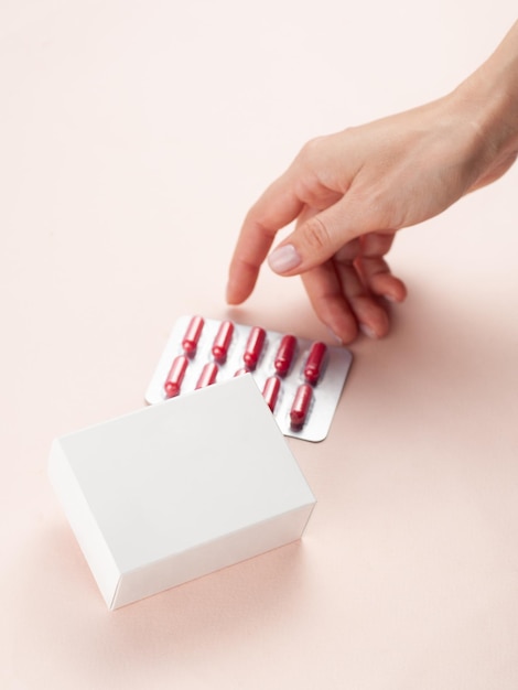 Zdjęcie makieta pustego opakowania białego produktu w kobiecej dłoni otwórz puste pudełko leku z vataminem w blistrze widok z góry miejsce na logo i tekst