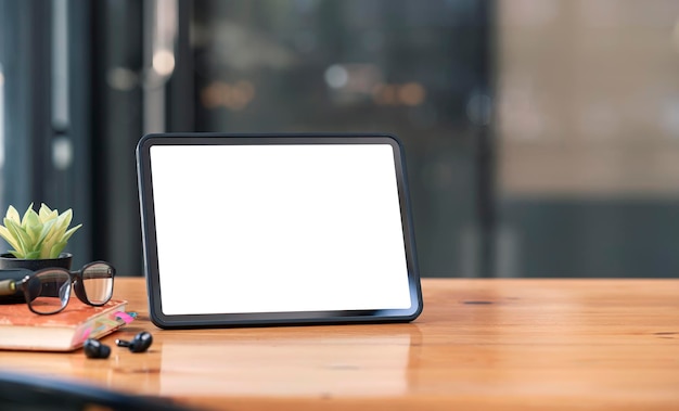 Makieta pusty biały ekran przenośny tablet na drewnianym stole z miejsca na kopię.