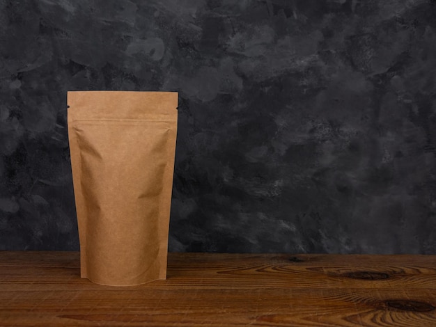 Makieta torby etui Pusty brązowy papier pakowy opakowanie z ziaren kawy drewniane tło reklama kopia przestrzeń