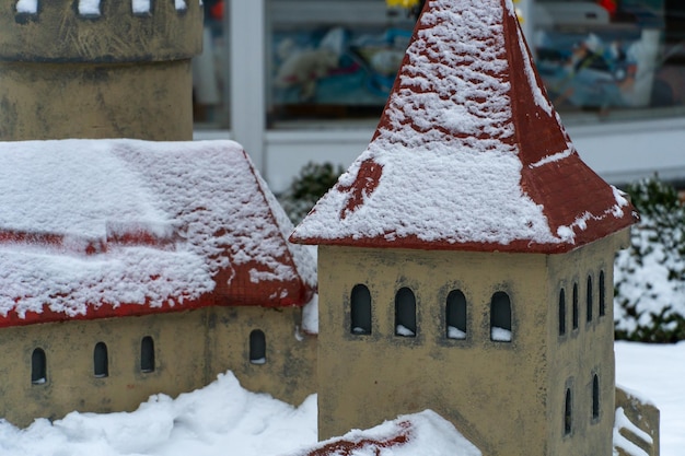 Makieta zabytkowego zamku w miniaturze w skansenie parkowym Muzeum Zima mroźna budowla dachy pokryte śniegiem Zameczek wykonany ręcznie z gliny