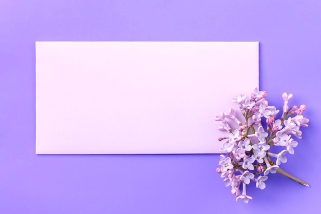 Makieta zaproszenia pusta pusta kartka z życzeniami z kopertą i kwiatem bzu