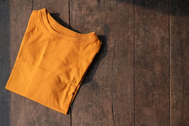 Zdjęcie makieta żółtej musztardy t-shirt na drewnianym tle