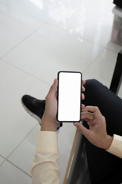 Makiety obrazu biznesmena trzymając inteligentny telefon huh biały ekran.