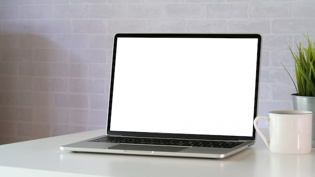 Makiety pusty ekran laptopa na białym obszarze roboczym