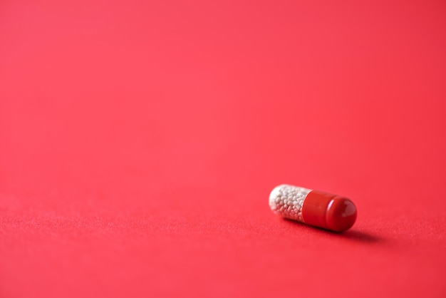 Zdjęcie makro czerwonych kapsułek na czerwonym tle. skopiuj miejsce wiązka leków, leczenie przeziębienia.