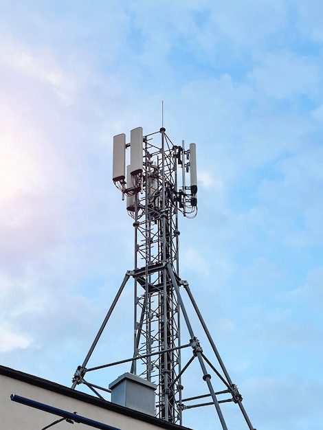 Makro stacja bazowa Sprzęt telekomunikacyjny sieci radiowej 5G z modułami radiowymi i inteligentnymi antenami zamontowanymi na metalu na tle chmur nieba Wieża telekomunikacyjna komórkowej 4G i 5G