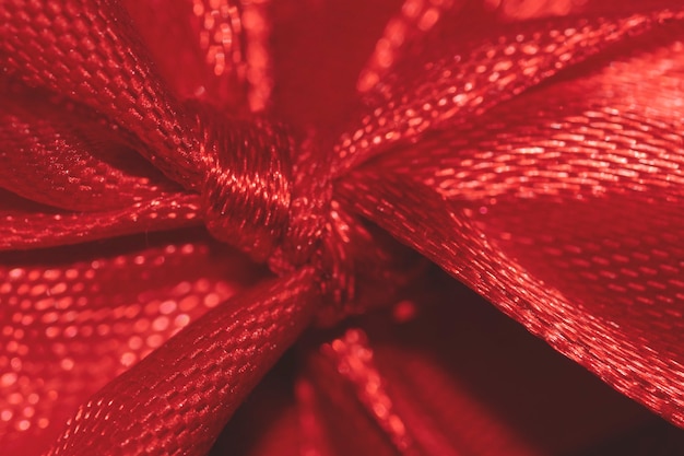 Makro szczegół czerwonej świątecznej wstążki łukowej świątecznej selektywnej ostrości tła