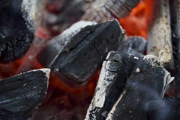 Makro zbliżenie rozżarzony węgiel na grillu. Płomienie ognia, węgla, żaru i dymu.