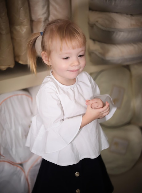 Mała blond dziewczynka w sklepie tekstylnym Uśmiechnięty portret