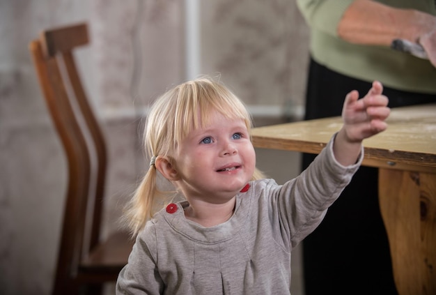 Mała blondynka o niebieskich oczach prosi o coś Portret