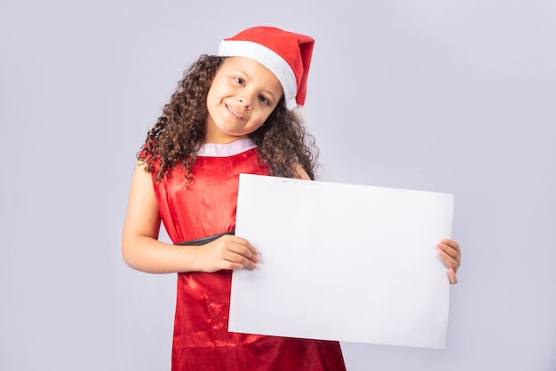 mała brazylijska dziewczyna ubrana w strój świąteczny, trzymając pusty plakat