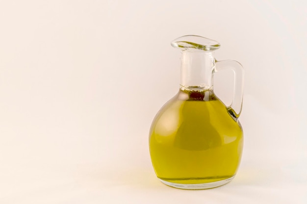 Mała butelka oliwy z oliwek na białym tle