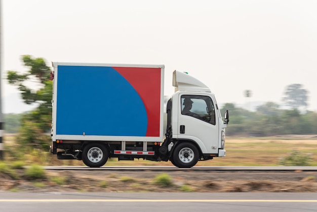 Mała ciężarówka jazdy na autostradzie Mała biała ciężarówka dostawcza szybko porusza się po dystrybucji drogowej Ekspresowa dostawa biznesowa