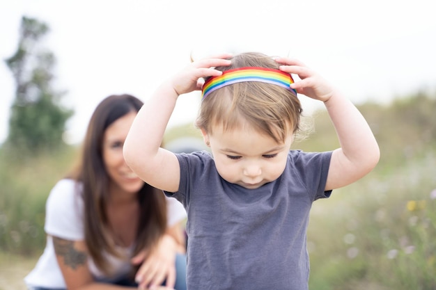 Mała dziewczynka bawi się opaską lgbt na zewnątrz